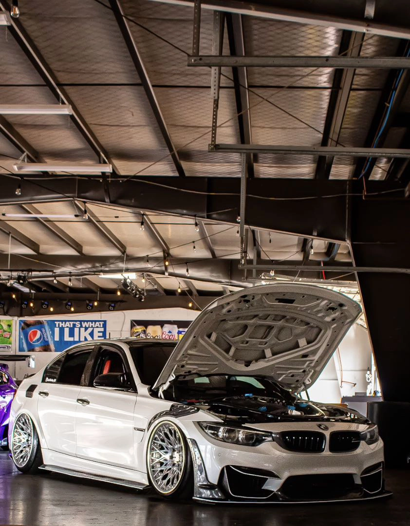 White 2018 BMW M3 Competition with polished two-piece wheels and the hood open