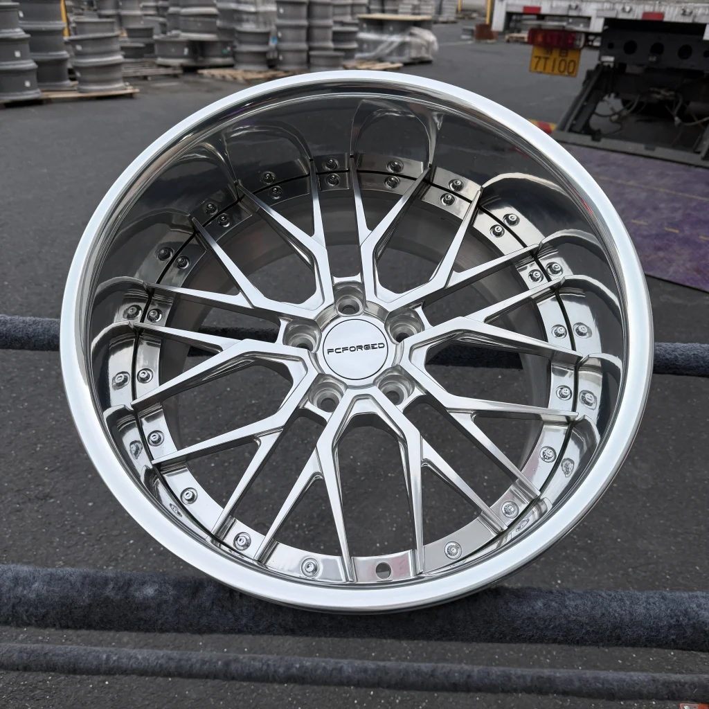 Close-up of a reflective multi-spoke FcForged wheel with fasteners around the rim.