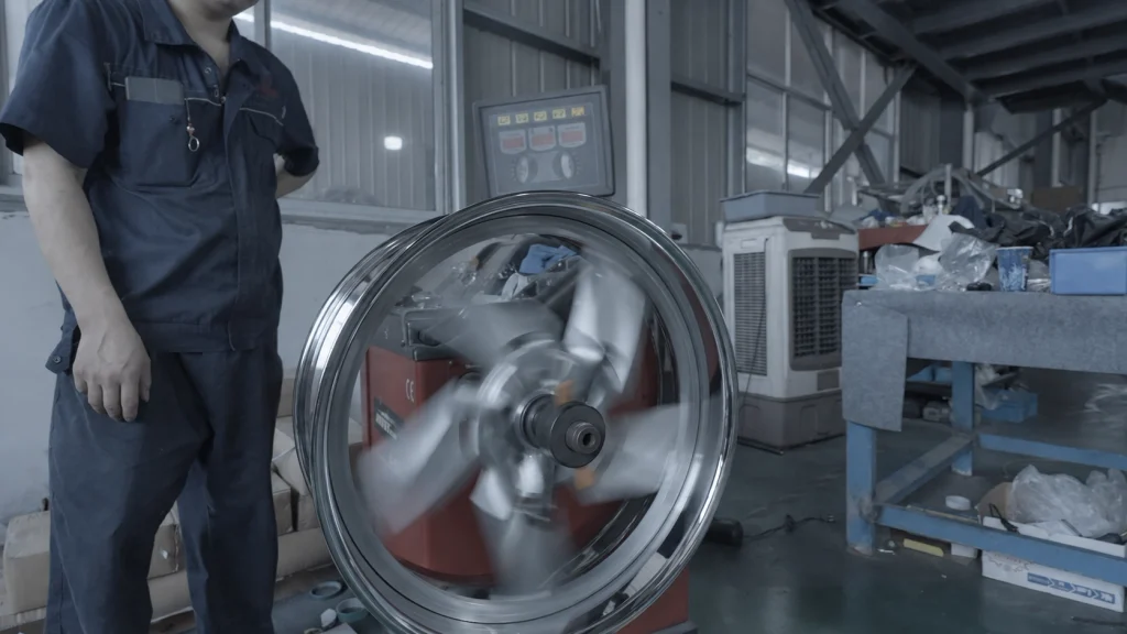 Technician monitoring a wheel rotating on a balancing machine