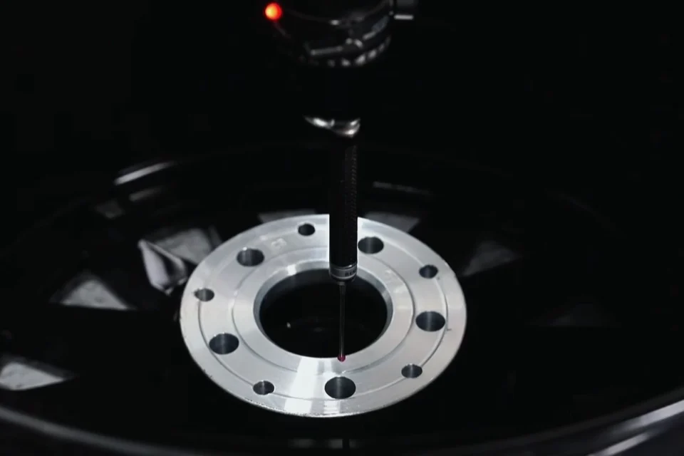 Measuring probe checking the center bore area of a forged wheel